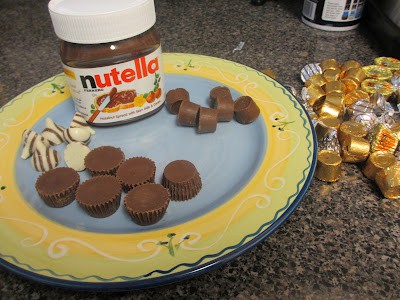 Herseys Kisses, small Reeses cups, Rolos and Nutella on a festive plate. 