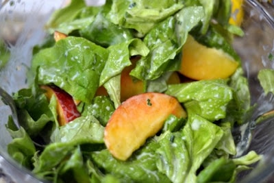 Salad greens with slices of peach. 