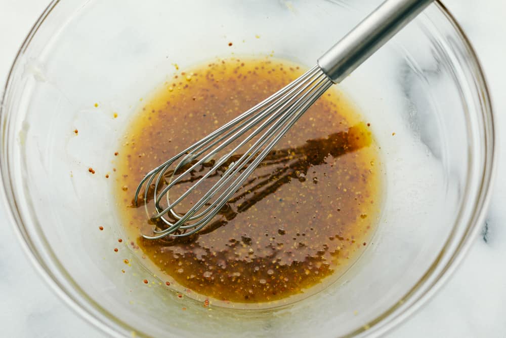 A glass bowl of ingredients being whisked together. 