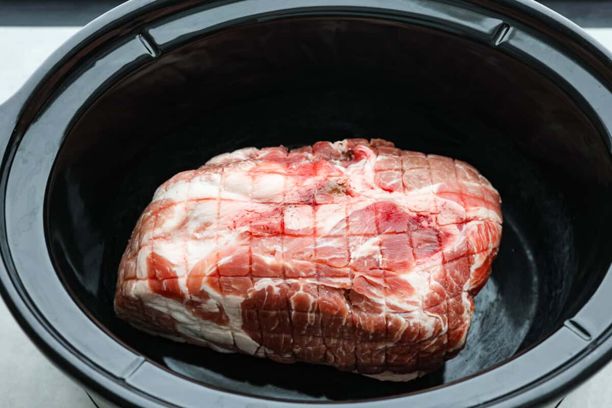 Overhead shot of pork roast in bottom of crock pot. 