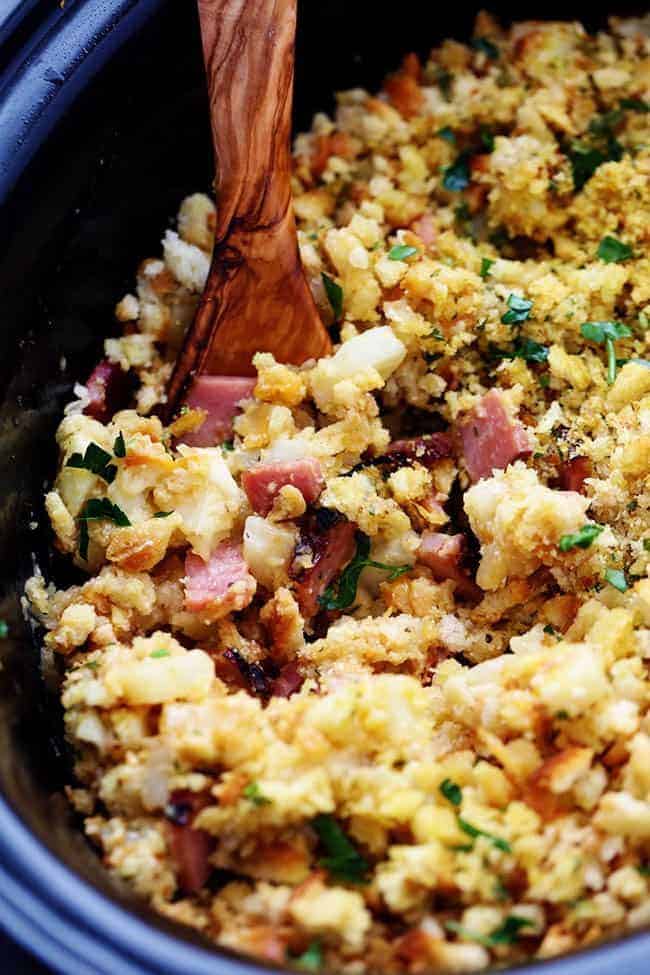 Slow Cooker Ham and Potato Casserole in a a slow cooker with a wooden spoon. 