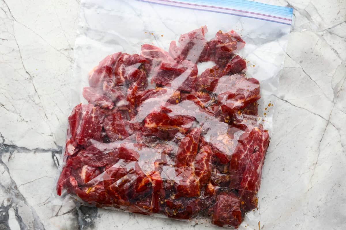 Overhead shot of flank steak in a ziploc bag with marinade. 