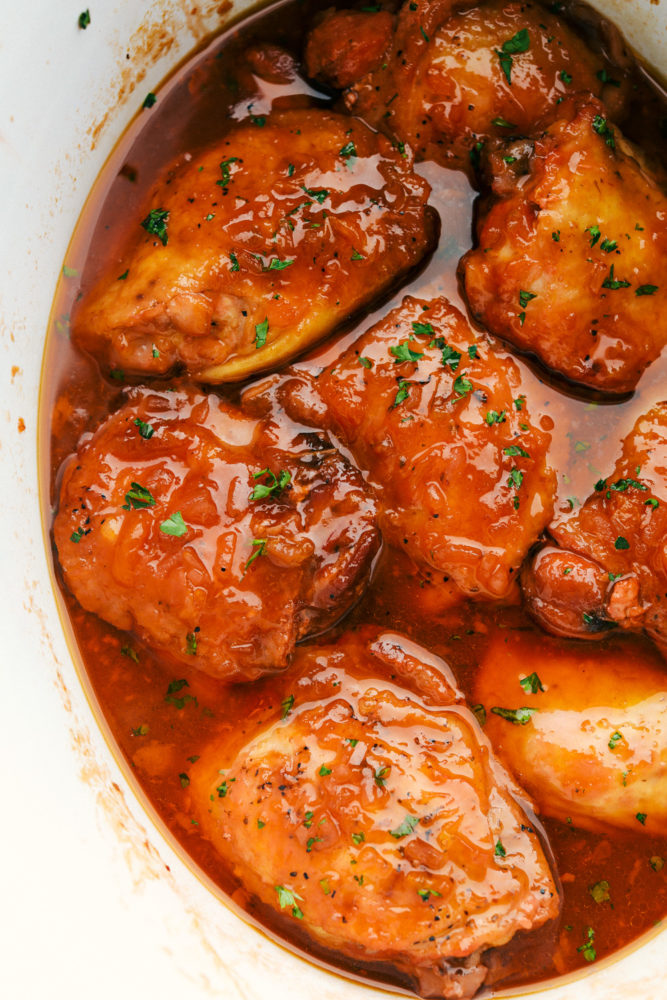 Top-down view of apricot chicken in a white serving dish.