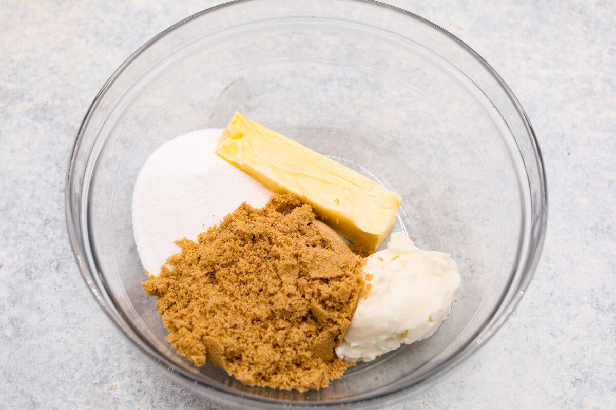 Overhead shot of the sugars, butter, and shortening in a glass bowl. 