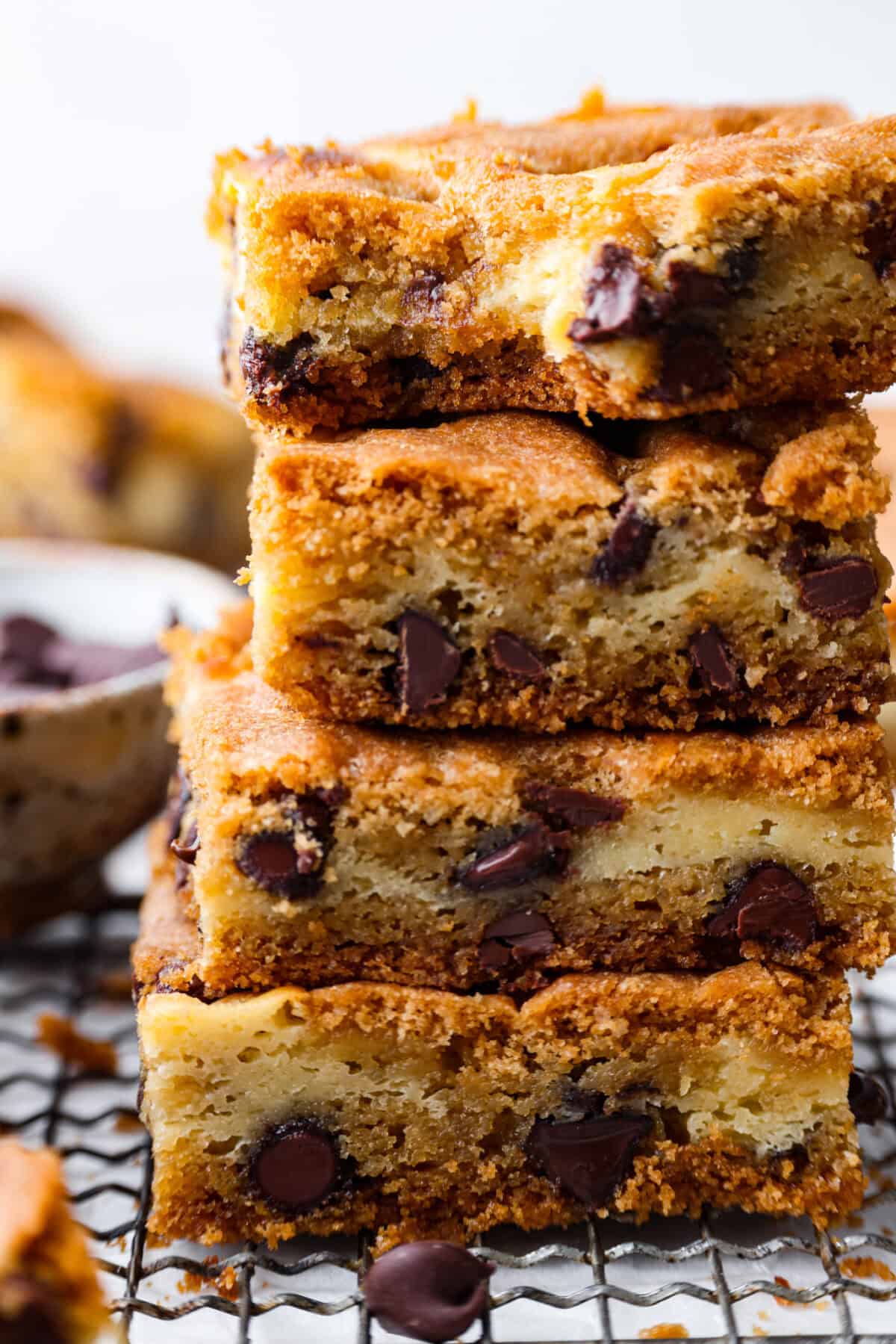 Close up shot of stacked chocolate chip cheesecake brownies. 