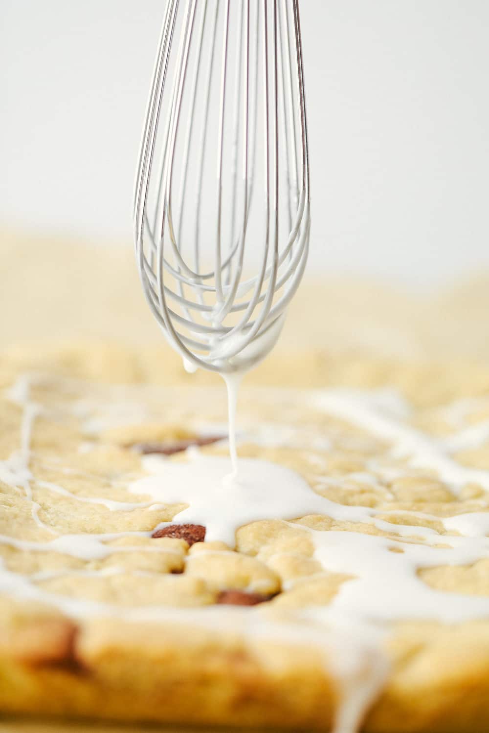 Snickerdoodle bars baked with a whisk drizzling over top a glaze. 