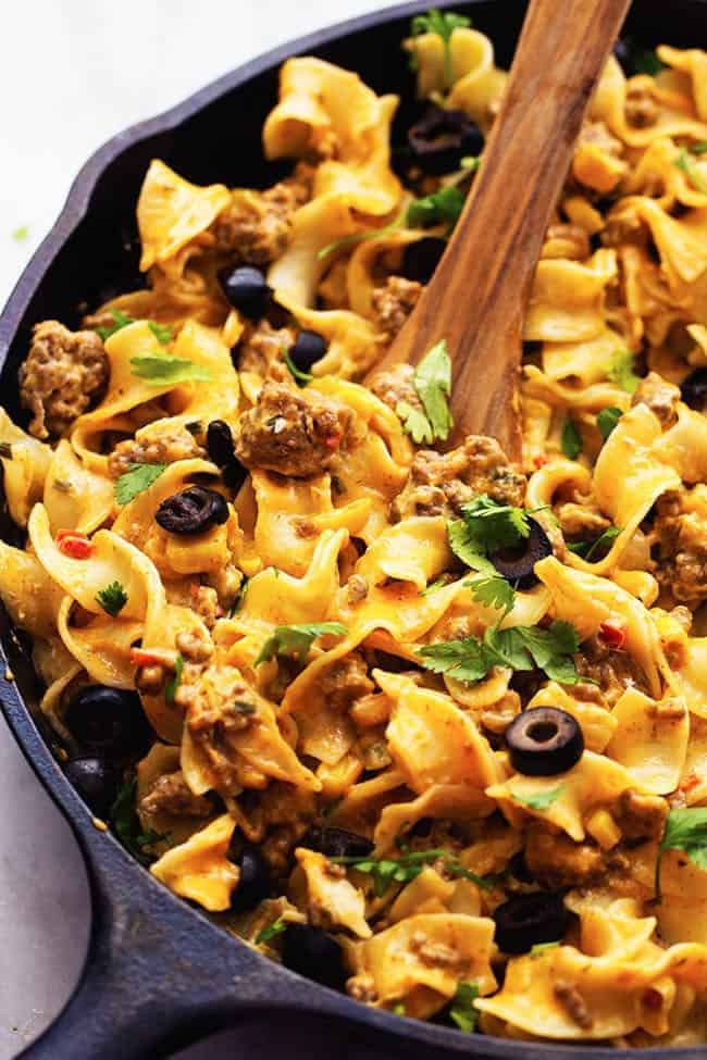 taco stroganoff in a cast iron skillet with a wooden spoon.