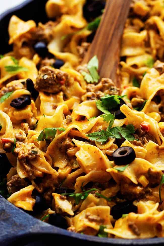 taco stroganoff in a cast iron skillet with a wooden spoon.