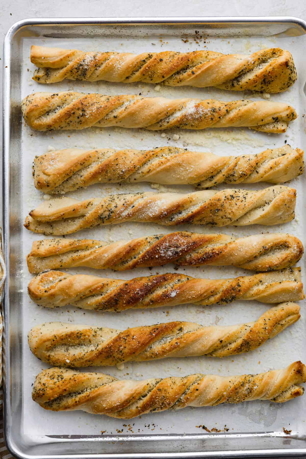 Overhead shot of baked homemade breadtwists on a baking sheet. 