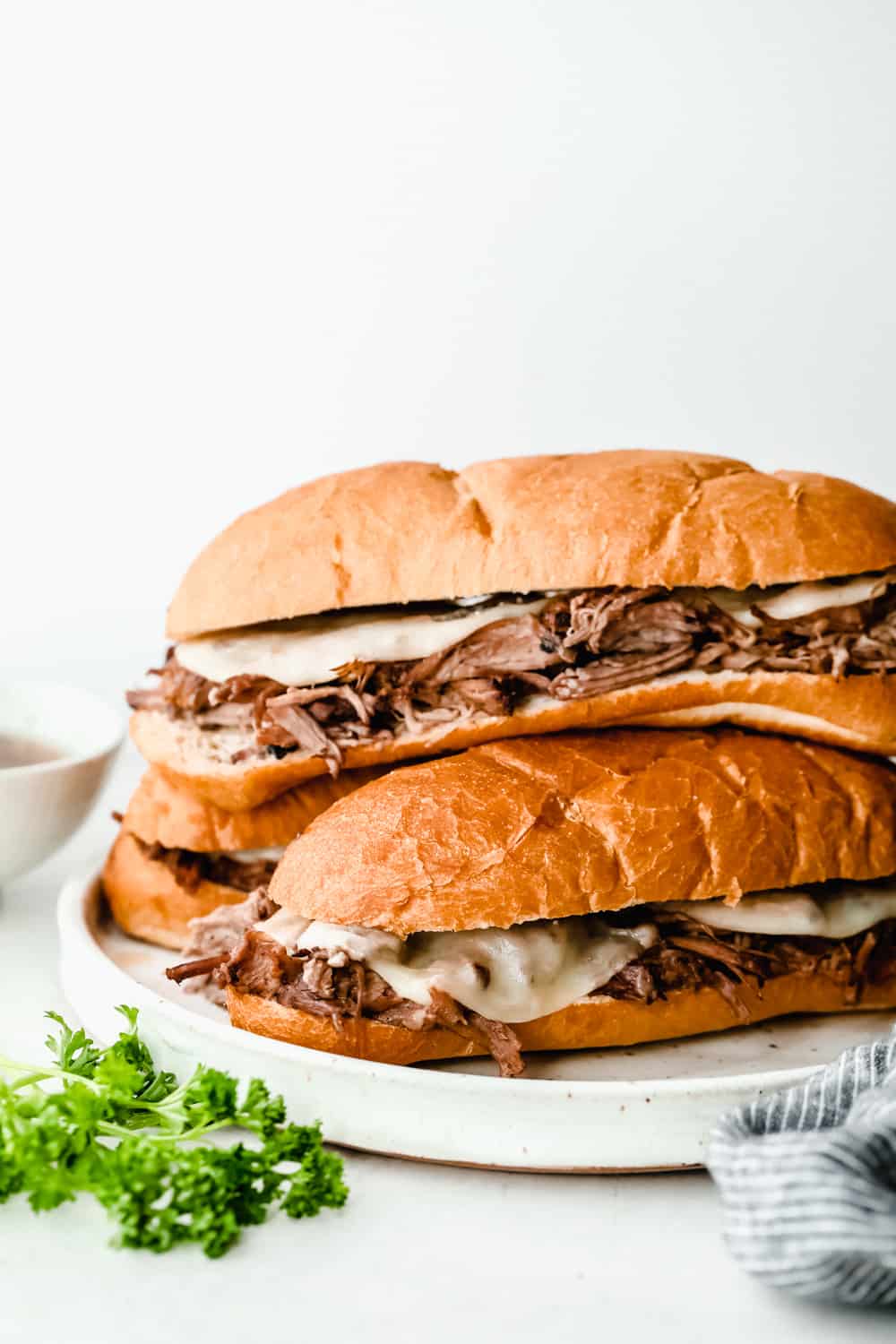 slow cooker French dip sandwiches stacked together 