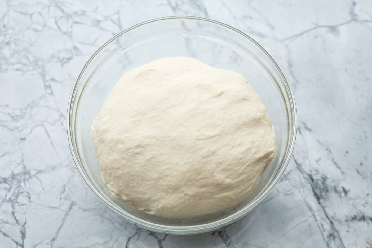 Overhead shot of dough ball in a glass bowl. 