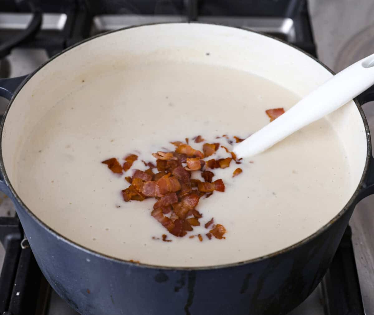 Close up shot of the creamy potato soup covered in crispy bacon bits. 