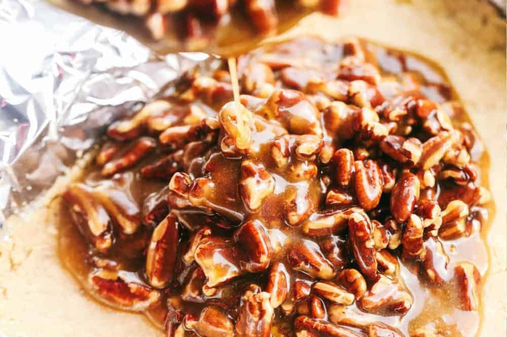 Pecan mixture being poured onto the crumb base. 