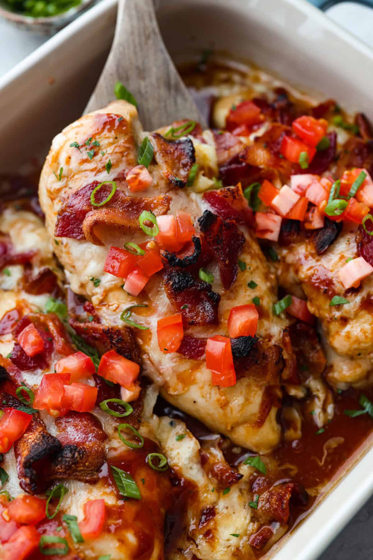 Close up shot of cooked Monterey chicken breast being lifted out of the baking dish, 