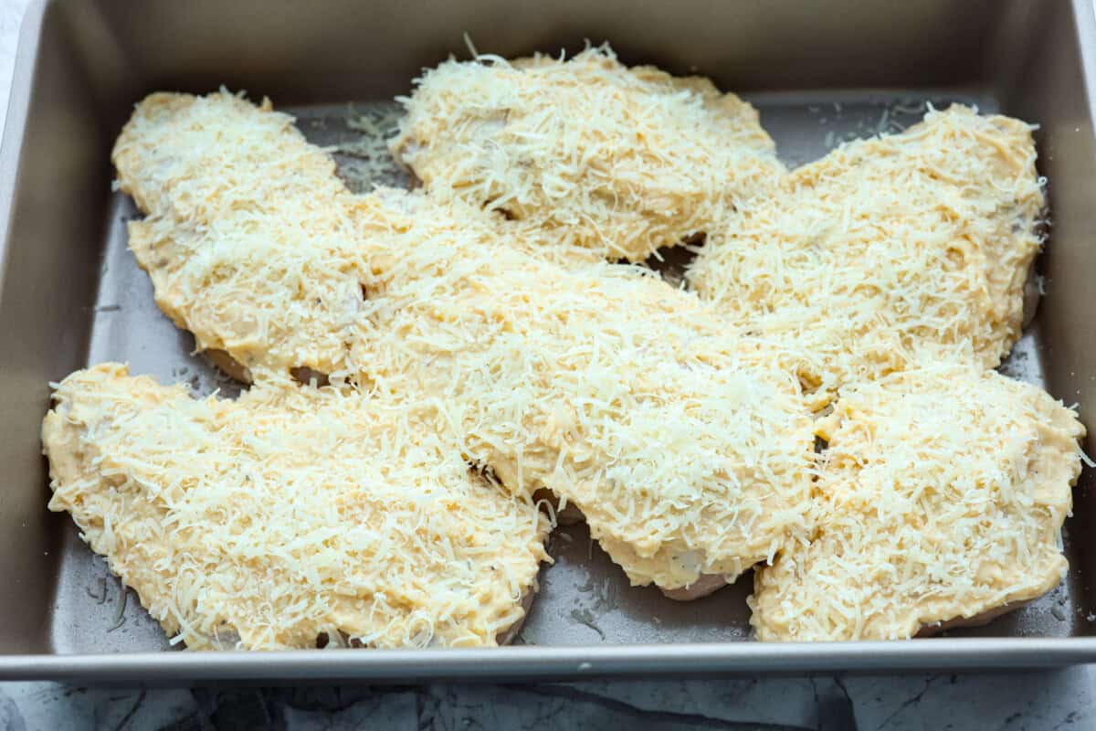 Overhead shot of chicken with mayo mixture and parmesan cheese sprinkled over the top.