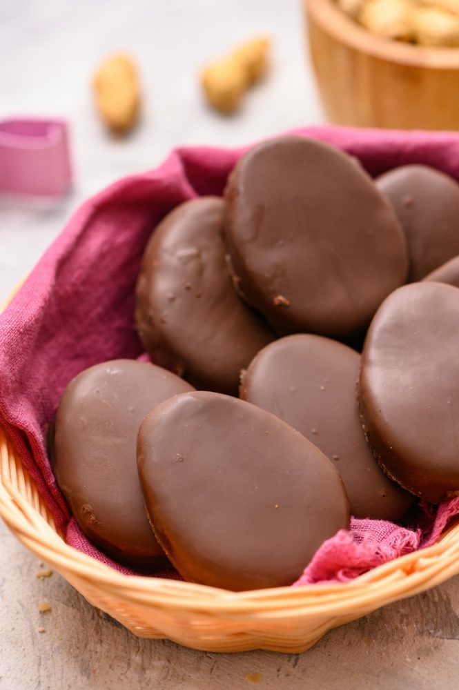 A basket (with a pink towel) full of reese's Easter eggs. 