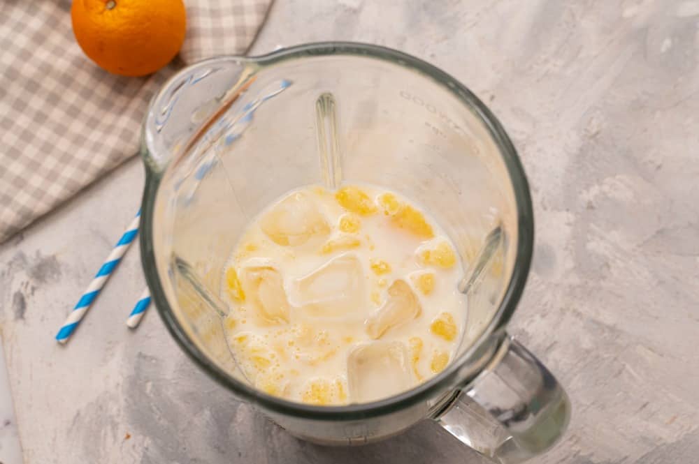 Ingredients for orange julius in a bender.