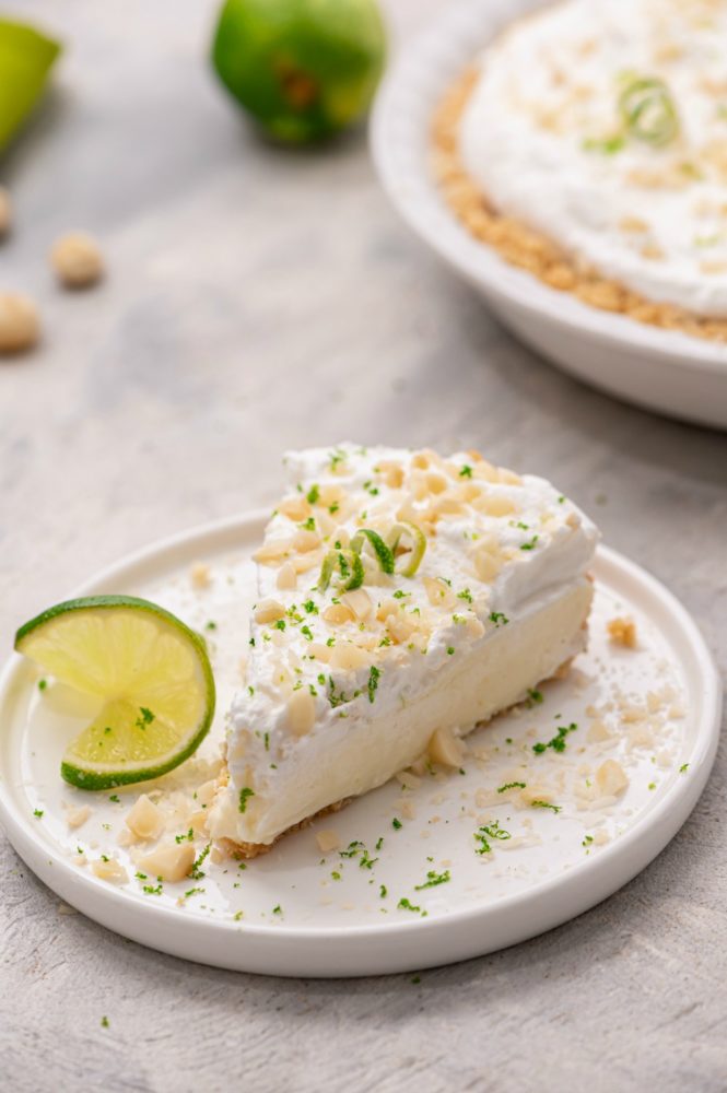 A slice of key lime pie on a white plate.