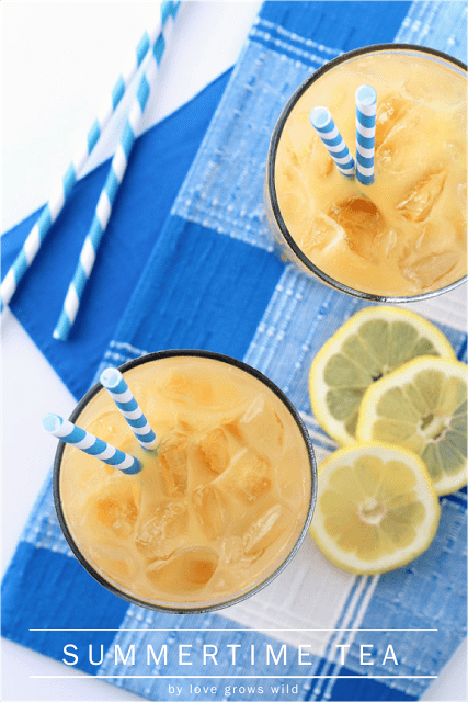 Summertime Tea in two glasses with blue and white straws and lemon slices on the side.