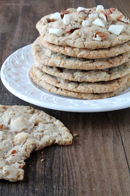 Giant White Chocolate Pecan Cookies in a stack on a white plate by Love Grows Wild for The Recipe Critic