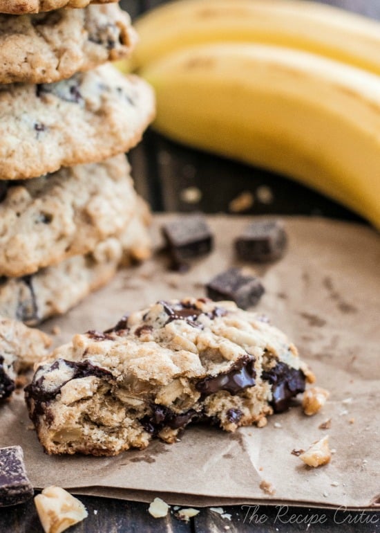 Stack of banana walnut chocolate chunk cookies beside a half of a cookie.