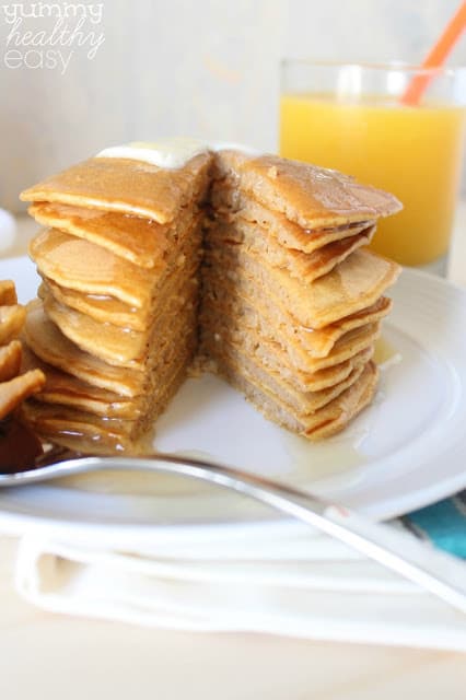 Stack of pumpkin pancakes with a slice cut out.