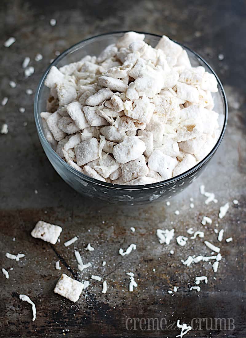 Vanilla coconut muddy buddies in a glass bowl.