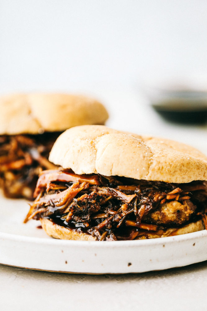 Pork sandwich sitting on a white plate. 