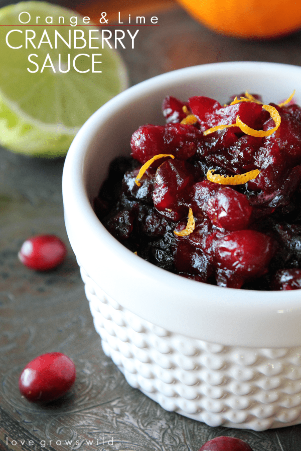 Orange and Lime Cranberry Sauce garnished with orange zest in a small white cup.