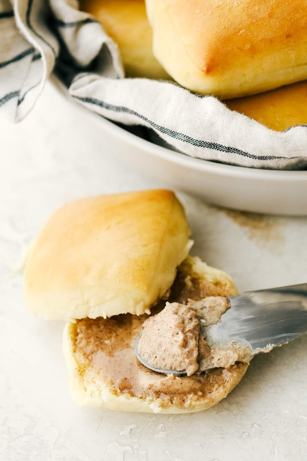 Cinnamon honey butter spread over top Texas Roadhouse rolls.