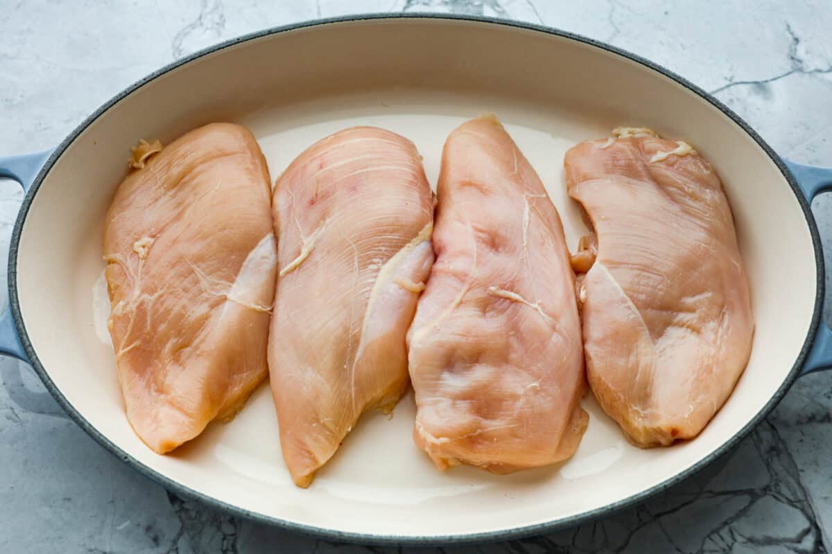 Overhead shot of chicken breasts in prepared baking dish. 