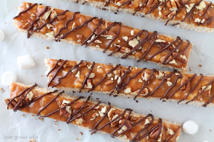 Classic rice krispie treats with a delicious turtle topping of creamy caramel, crunchy pecans, and a decadent chocolate drizzle! | Love Grows Wild for okhealthlyliving.com