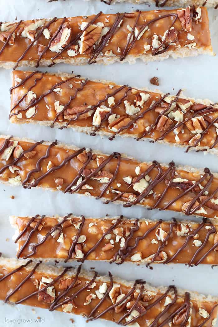 Classic rice krispie treats with a delicious turtle topping of creamy caramel, crunchy pecans, and a decadent chocolate drizzle! | Love Grows Wild for okhealthlyliving.com