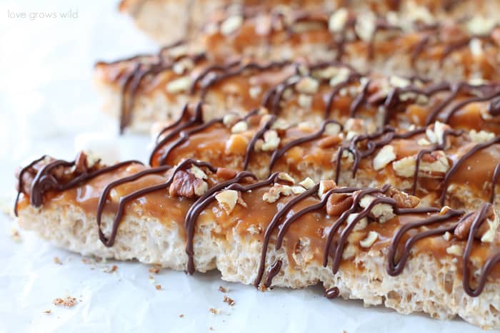 Classic rice krispie treats with a delicious turtle topping of creamy caramel, crunchy pecans, and a decadent chocolate drizzle! | Love Grows Wild for okhealthlyliving.com