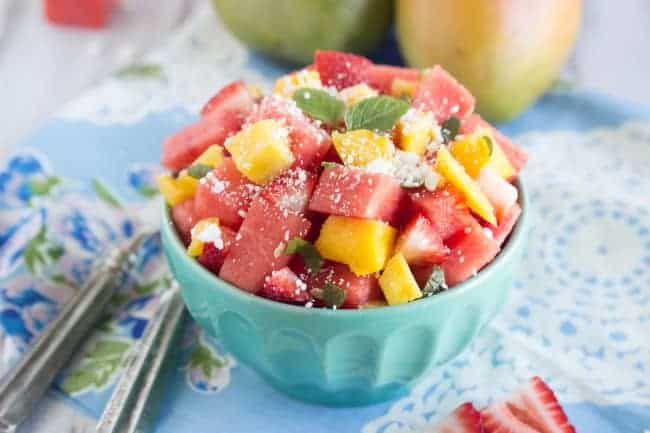 Fresh watermelon and Feta Salad in a blue bowl with metal forks. 