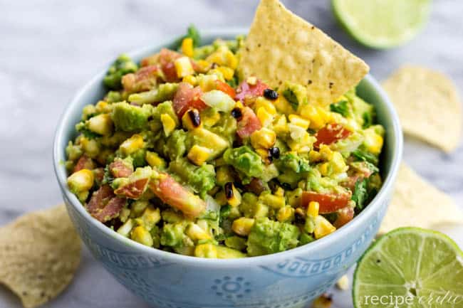 Grilled guacamole dip with a chip in the bowl. 