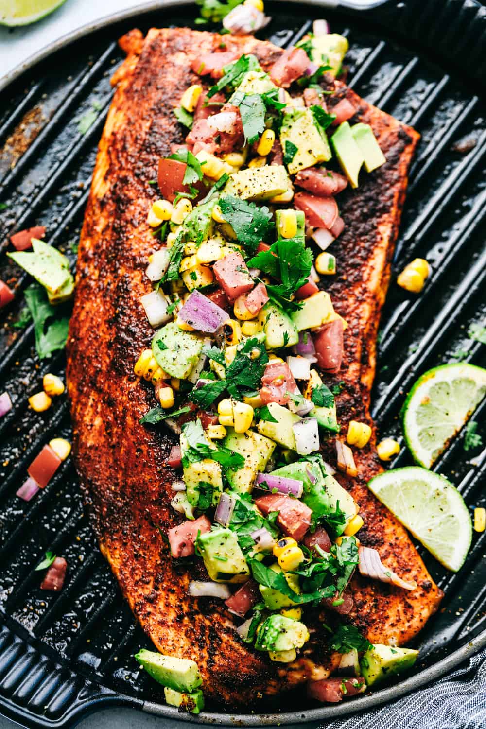 Grilled Salmon topped with Avocado Salsa on a grill.