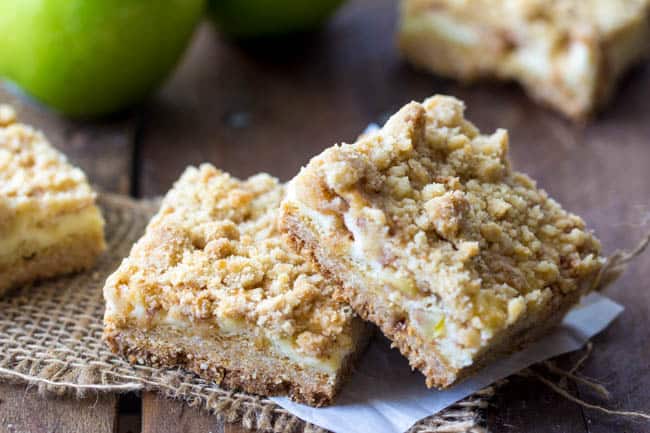 sour cream apple crumb bars stacked on top of each other. 