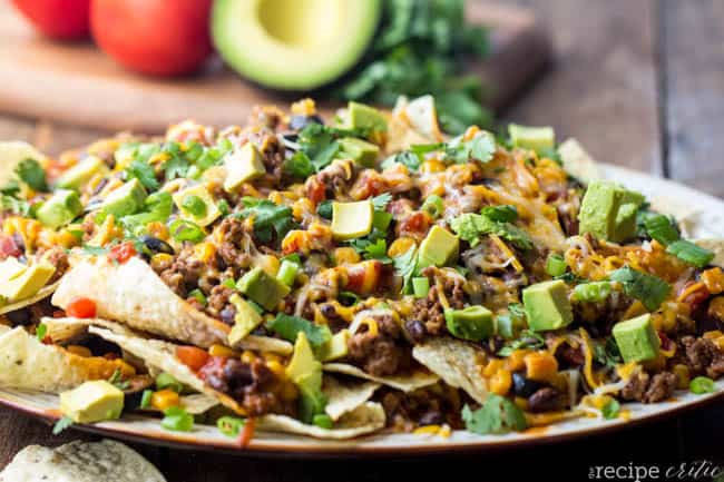 Beefy enchilada nachos stacked on top of each other.