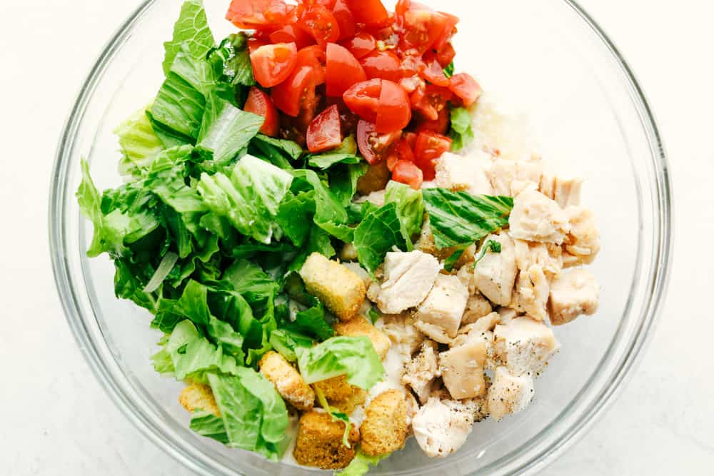 Fresh Ingredients for the Chicken Caesar Salad Wrap in a clear glass bowl.