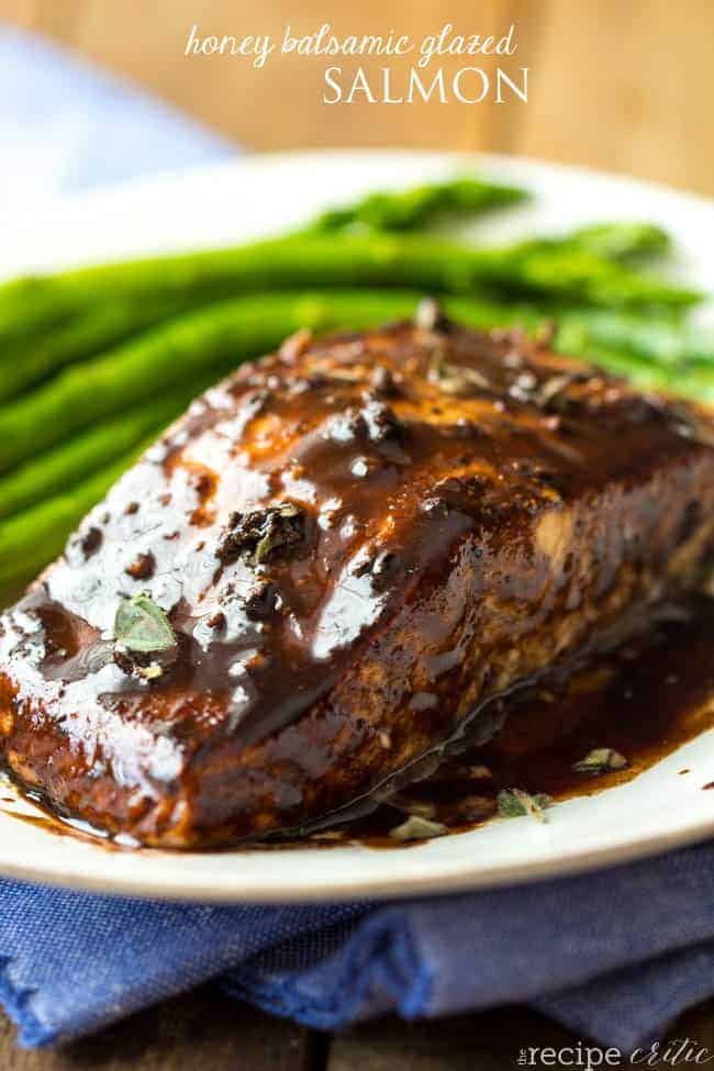 Honey balsamic glazed salmon on a white plate with asparagus on the side. 