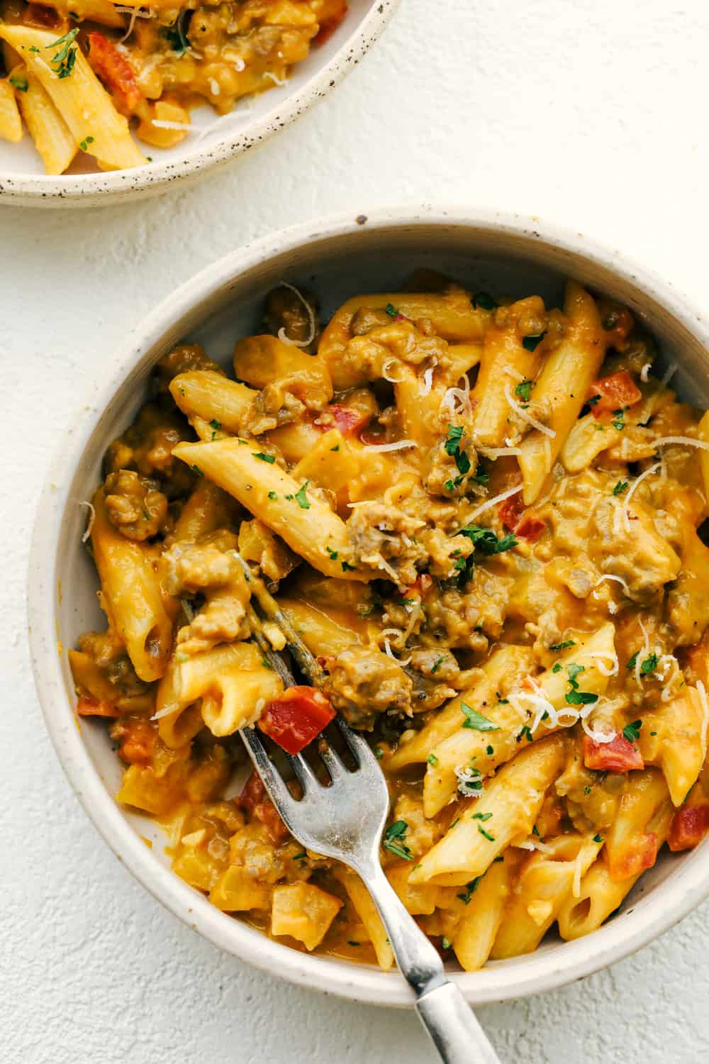 Sausage pumpkin pasta in a bowl with a fork. 