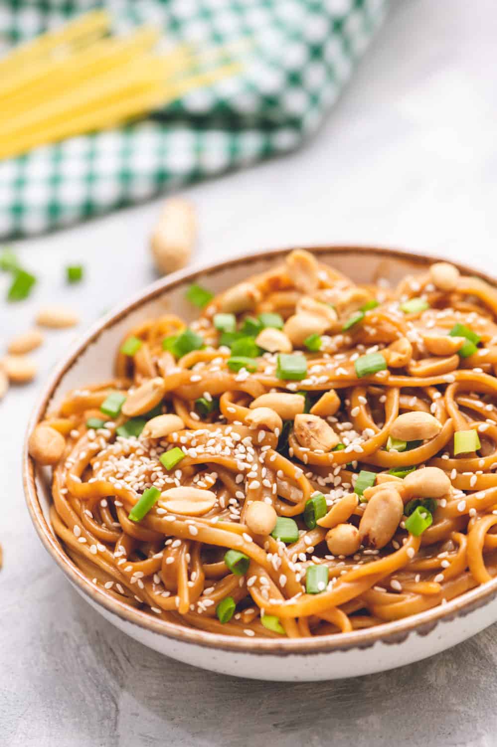 Thai peanut sesame noodles in a bowl with scallops and sesame seeds as garnish.