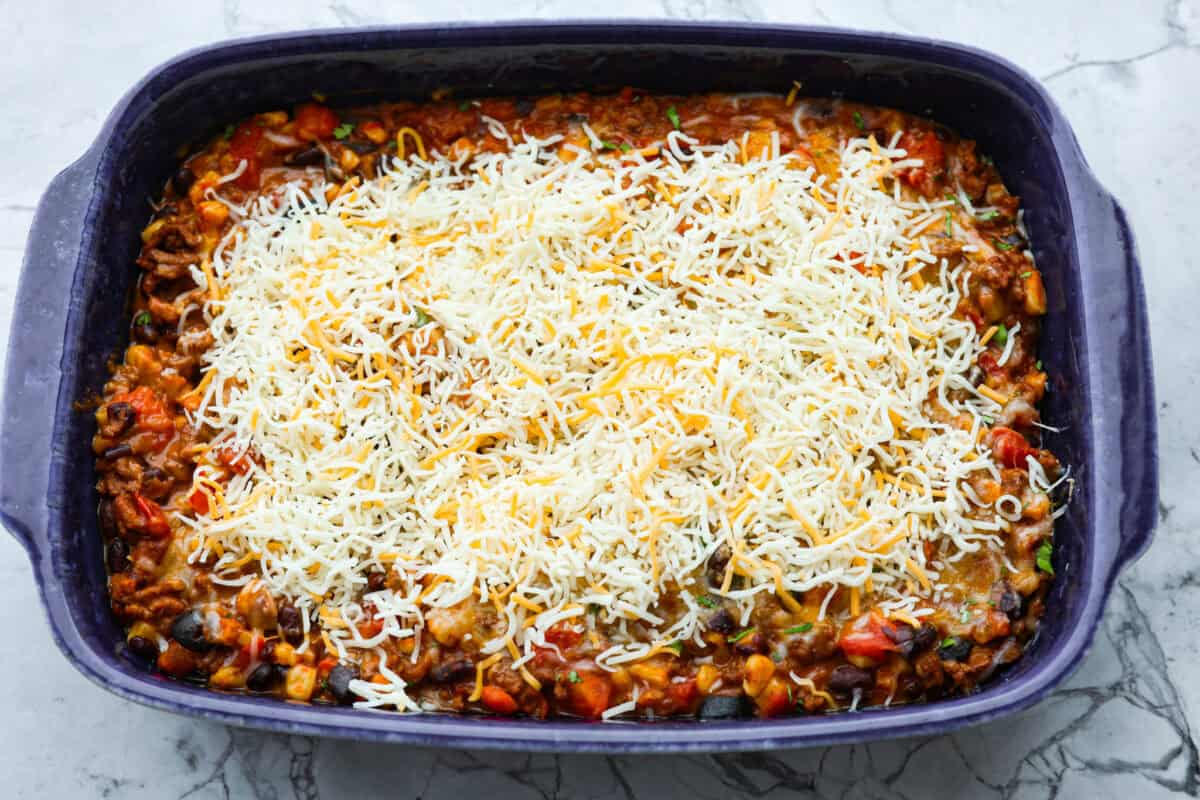 Overhead shot of enchilada dip with cheese sprinkled on top. 