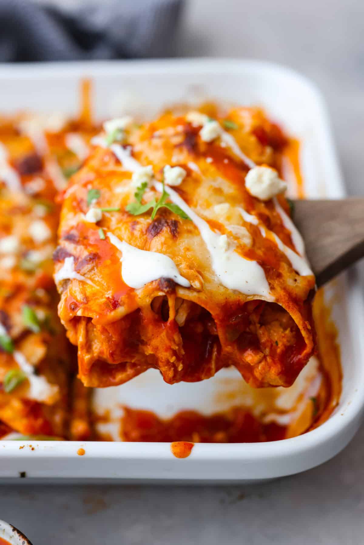 Close side view of buffalo chicken enchiladas on a serving spatula.