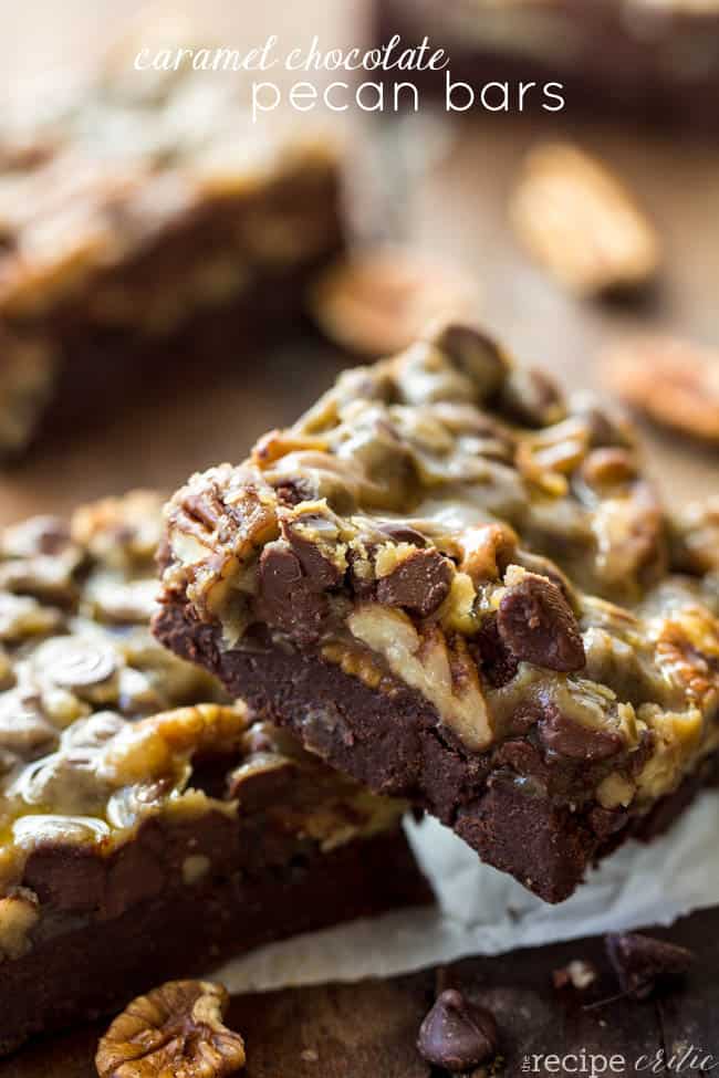 Caramel chocolate pecan bars stacked on top of each other. 