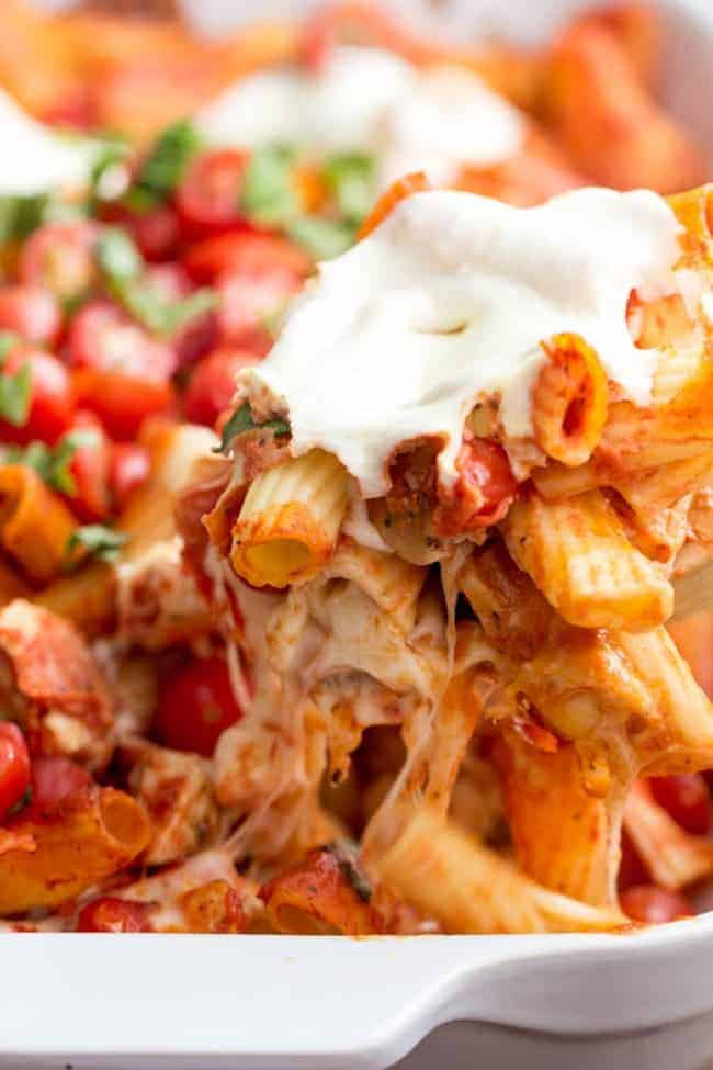 Chicken caprese pasta casserole in a white casserole dish. 