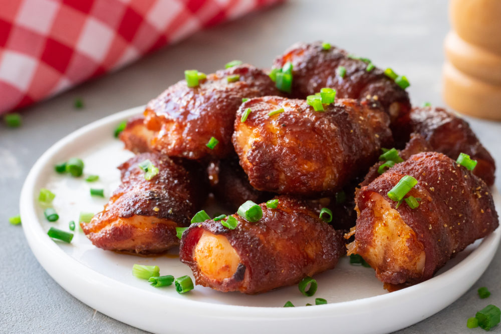 Chicken bites stacked on top of each other on a white plate. 