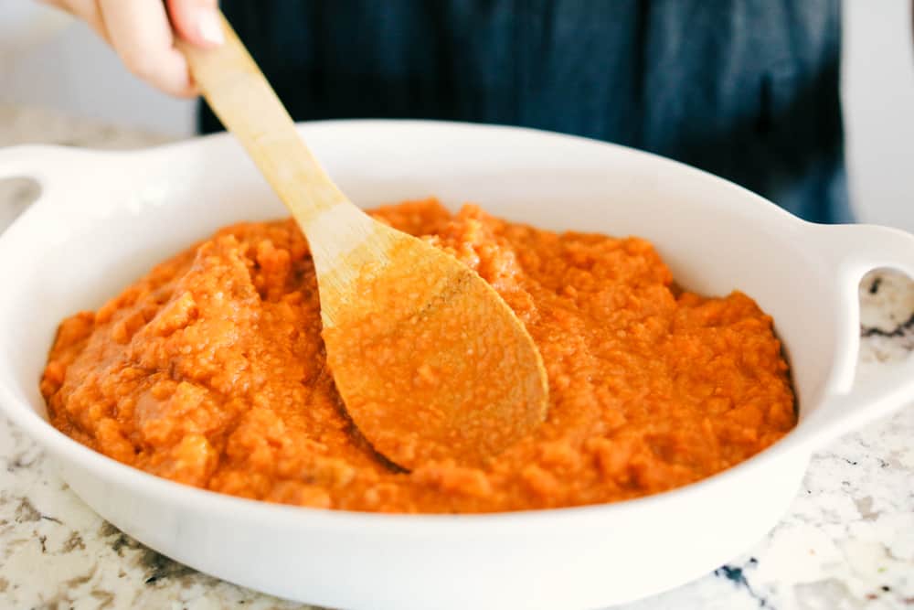 Adding sweet potato mixture to casserole dish.