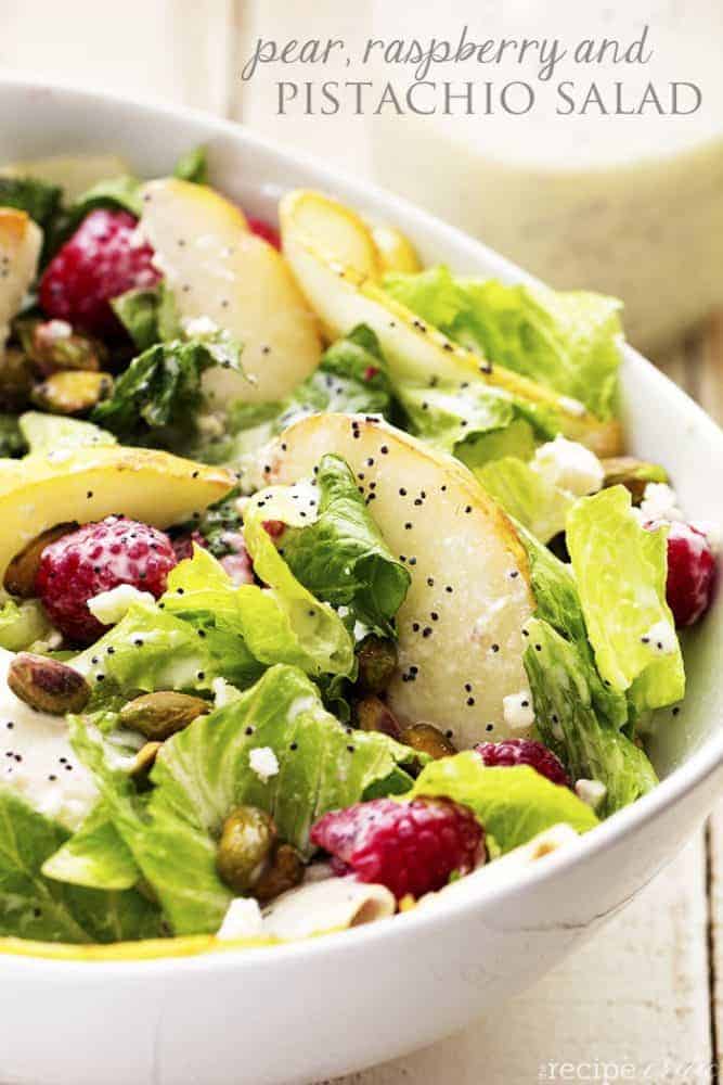 Large white bowl of pear raspberry pistachio salad.